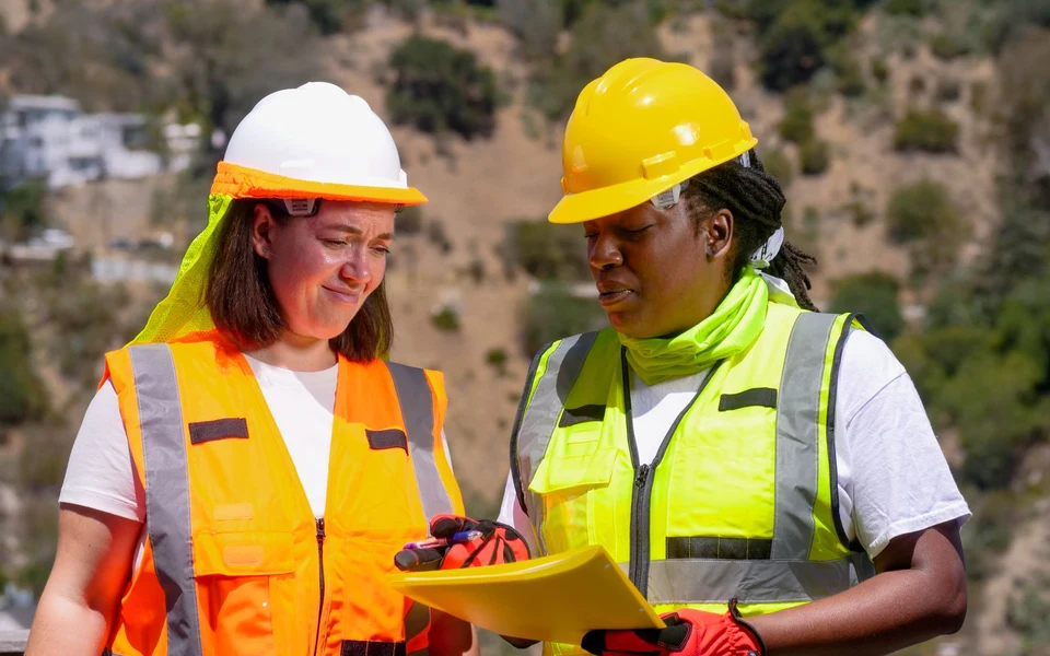 Safety-equipped engineers reviewing a work plan; illustrative stock photograph, not Formativelabz people or facilities
